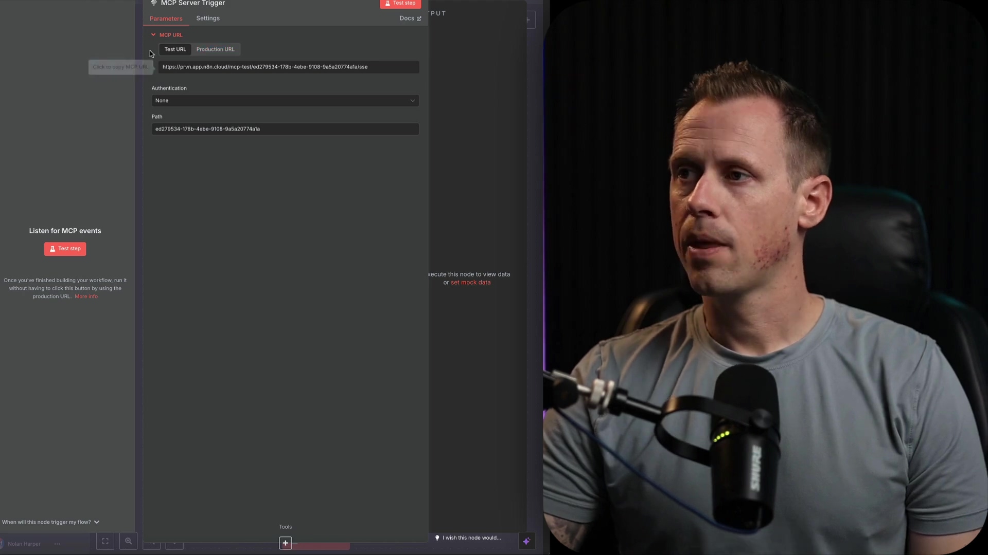 The image shows a split view with an n8n interface on the left and a man speaking on the right. The n8n interface is dark-themed and displays the 'MCP Server Trigger' node settings. The 'Parameters' tab is active, showing options for 'Test URL' and 'Production URL'. Below this, an input field contains a URL starting with 'https://pm-app.did.cloud/mcp-test/'. There's also an 'Authentication' dropdown set to 'None' and a 'Path' input field with a hexadecimal string. A 'Click to copy MCP URL' button is visible. On the right side, the man from the previous image is shown in a close-up, looking slightly to the right with a serious expression. He is wearing a grey t-shirt and a microphone in front of him. The background is dark with subtle lighting.