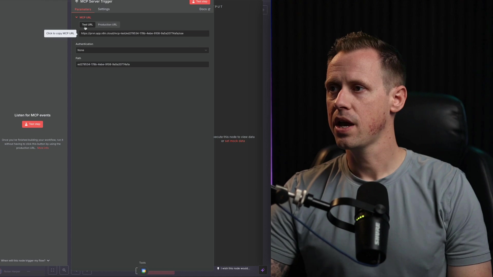 The image shows a split view with an n8n interface on the left and a man speaking on the right. The n8n interface is dark-themed and displays the 'MCP Server Trigger' node settings. The 'Parameters' tab is active, showing options for 'Test URL' and 'Production URL'. An input field contains a URL starting with 'https://pm-app.did.cloud/mcp-test/'. There's also an 'Authentication' dropdown set to 'None' and a 'Path' input field with a hexadecimal string. A 'Click to copy MCP URL' button is visible. The man on the right, wearing a grey t-shirt, is looking slightly to the right with a neutral expression. He has a microphone in front of him, and the background is dark with subtle lighting.