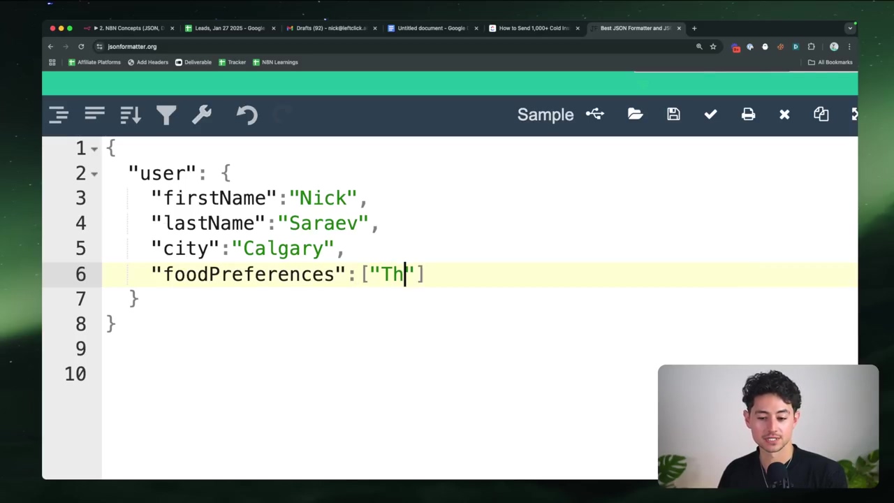 The image displays a code editor interface, likely for JSON data, with a young man visible in the bottom right corner. The main panel shows lines of code, specifically a JSON object with 'user' as the top-level key. Nested within 'user' are 'firstName', 'lastName', 'city', and 'foodPreferences'. The 'foodPreferences' array is currently being edited, with 'Th' partially typed. The interface includes a top bar with navigation tabs like 'N8N Concepts JSON', 'Leads, Jan 27 2020', 'Drafts', 'Untitled document', 'How to Send 1,000+ Cold Emails', and 'Best JSON Formatter and Validator'. Below the tabs, there's a toolbar with various icons and a 'Sample' dropdown. The background appears to be a blurred green and black pattern.