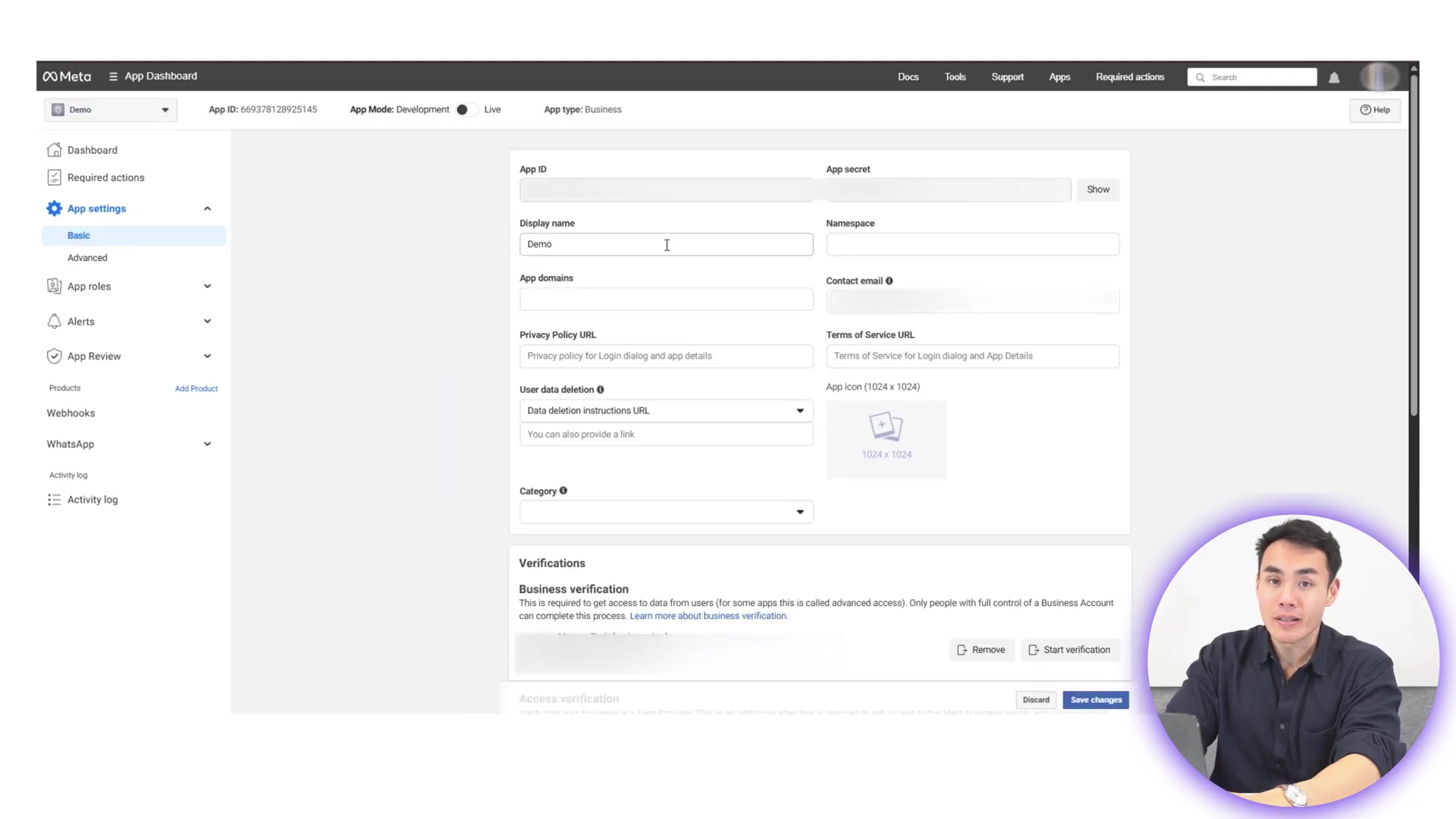 The image shows a screenshot of the Meta for Developers dashboard, specifically the 'Basic' settings page for an application. The left sidebar displays navigation options under 'App settings' including 'Basic' and 'Advanced', and other categories like 'App roles', 'App Review', 'Webhooks', 'Products', and 'WhatsApp'. The main content area shows fields for 'App ID', 'App secret', 'Display name' (with 'Demo' entered), 'Namespace', 'App domains', 'Privacy Policy URL', 'Data deletion instructions URL', 'App icon', and 'Category'. Below these are sections for 'Verifications' and 'Access verification'. A man's face is visible in the bottom right corner, partially obscuring the 'Discard' and 'Save changes' buttons.