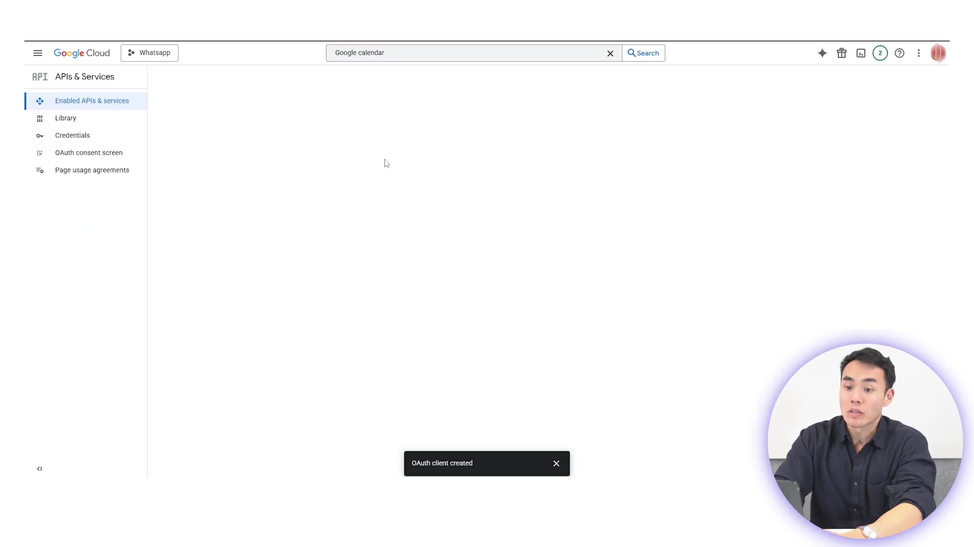 The image displays a Google Cloud interface with a sidebar menu on the left and a main content area that is mostly empty. The sidebar shows 'API & Services' expanded, with sub-items like 'Enabled APIs & services', 'Library', 'Credentials', 'OAuth consent screen', and 'Page usage agreements'. At the top, there's a search bar labeled 'Google calendar' with a search icon. A small black notification bar at the bottom center reads 'OAuth client created'. In the bottom right corner, a man is visible in a circular overlay, looking at the screen with a focused expression.