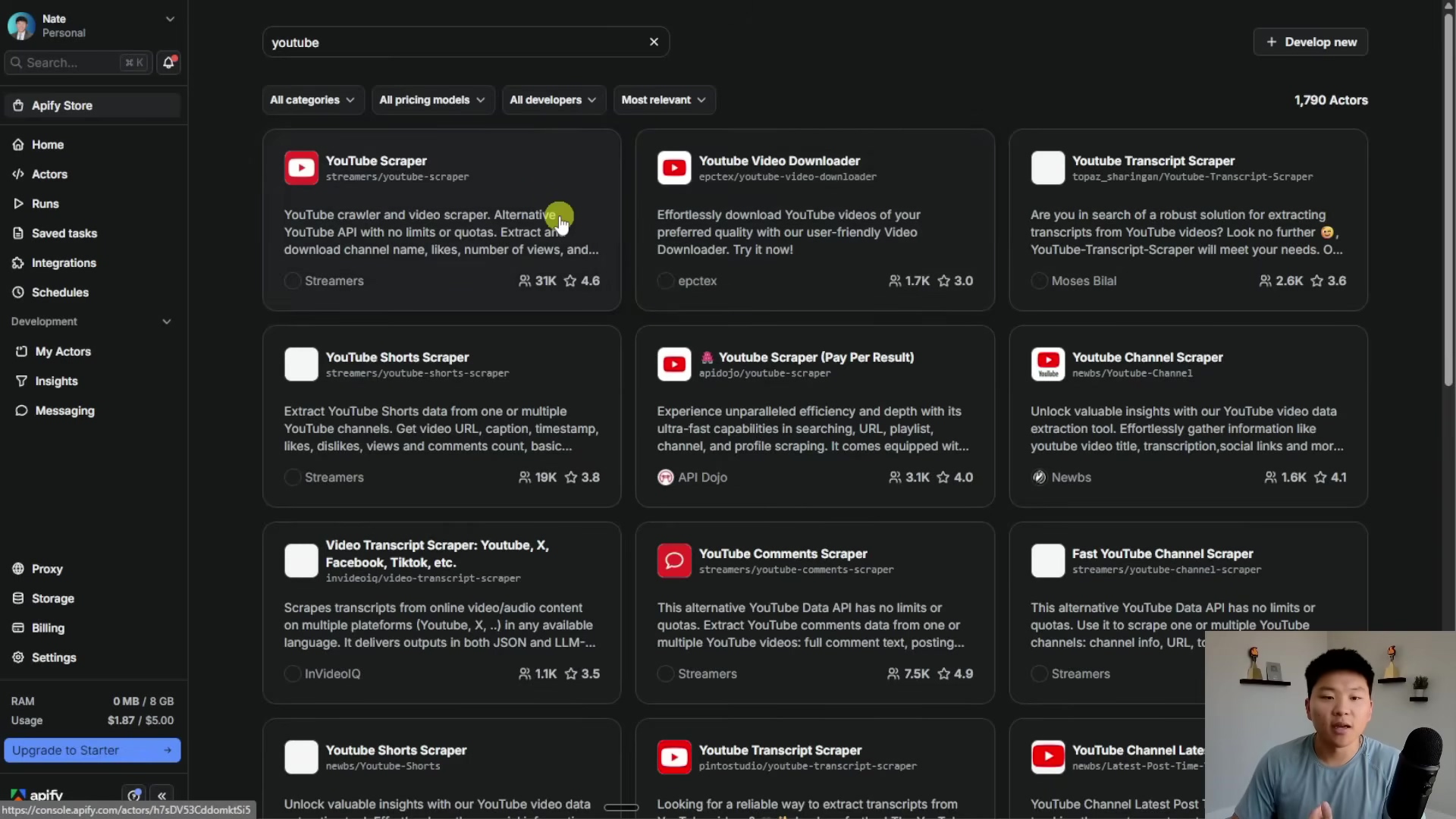The image displays a computer screen showing the Apify Store interface, specifically a search for 'youtube' related actors. The screen is divided into a left sidebar with navigation options and a main content area displaying various 'Actors' (automation tools). The main content area shows several cards for YouTube-related scrapers and downloaders, each with a title, description, developer, and ratings. The top right corner shows '1,790 Actors'. A man with short dark hair and a black t-shirt is visible in the bottom right corner of the screen, looking towards the left.