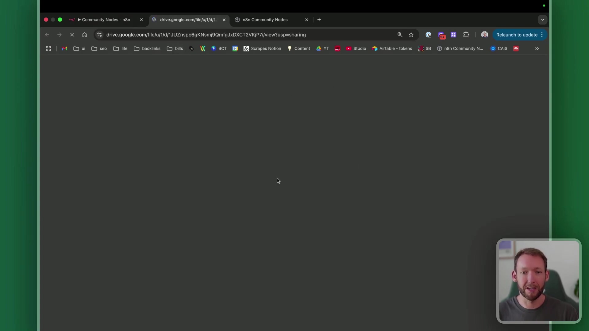The image shows a web browser window with a dark gray background, indicating a loading or blank page. The URL bar at the top displays 'drive.google.com/file/d/1JUzInpcBqKNsmjBQmfqJxcDXCT2YKjP7j/view?usp=sharing', suggesting a Google Drive file is being accessed. Multiple tabs are open, including 'n8n Community Nodes' and 'drive.google.com/file/u/1/'. The browser interface elements like back/forward arrows, refresh button, and extensions are visible. A video overlay of a man speaking is present in the bottom right corner. The background outside the browser window is a textured green.