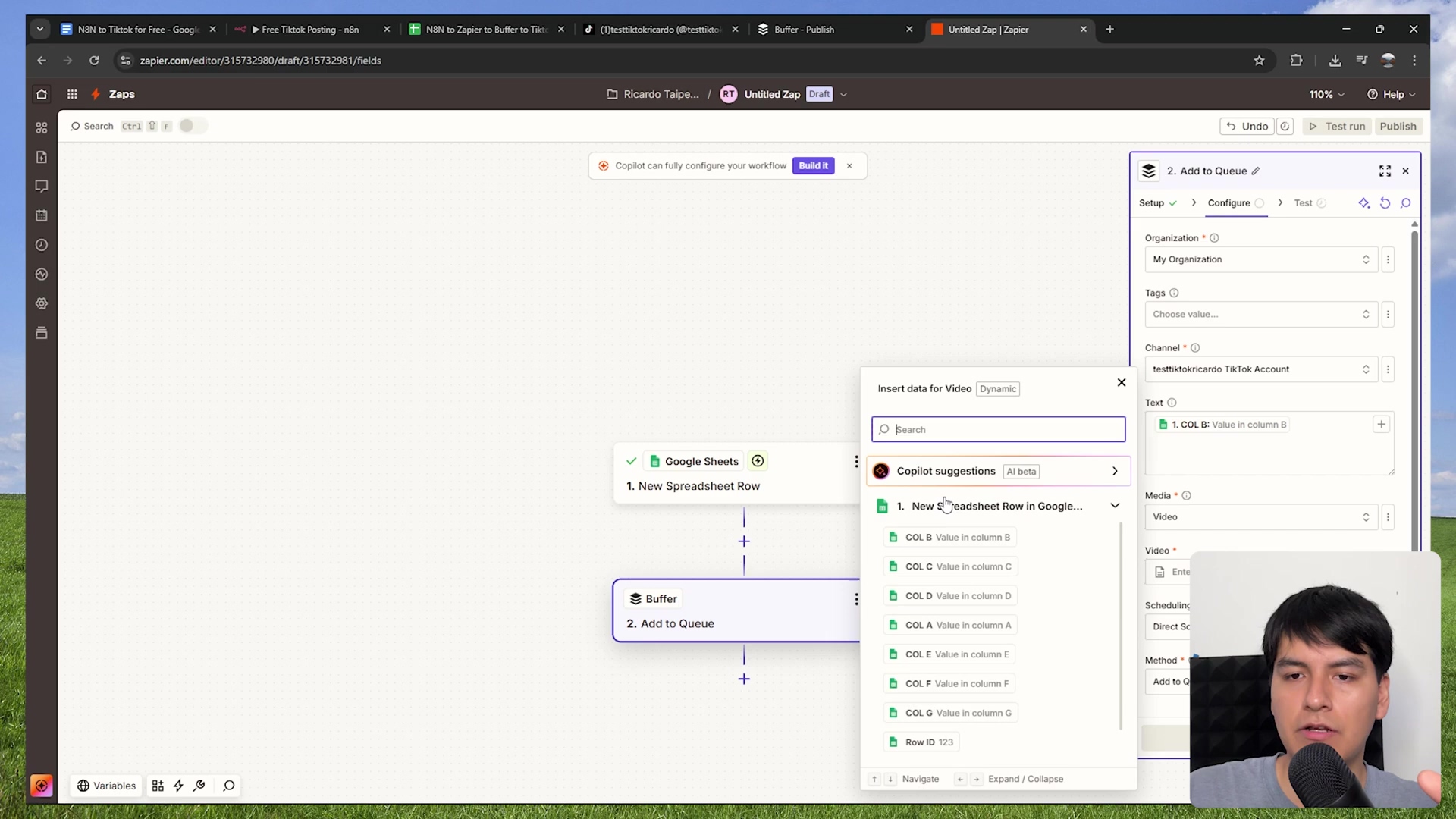 The image shows a Zapier interface, continuing the workflow setup. The central canvas displays '1. New Spreadsheet Row' from Google Sheets connected to '2. Add to Queue' from Buffer. A dynamic data insertion menu is open, showing 'Insert data for Video' and a list of available fields from the Google Sheets trigger, such as 'New Spreadsheet Row in Google...', 'COL B: Value in column B', 'COL C: Value in column C', etc. The right sidebar is focused on '2. Add to Queue' for Buffer, with sections for 'Organization', 'Tags', 'Channel', 'Text', and 'Media'. The 'Text' field shows '1. COL B: Value in column B'. The 'Media' section has a 'Video' input field. A person is visible in the bottom right corner, looking at the screen.
