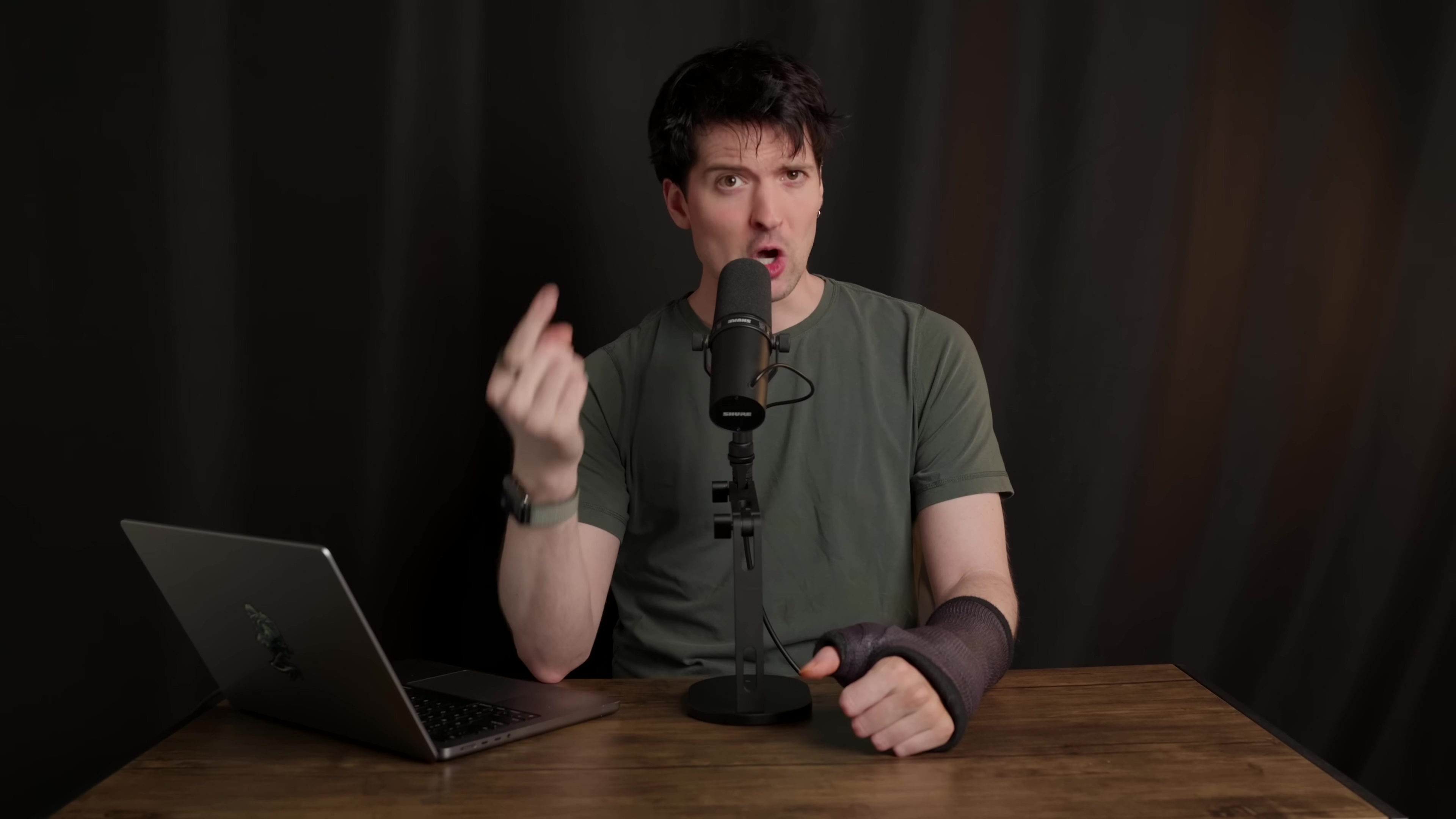 Man speaking into microphone, gesturing