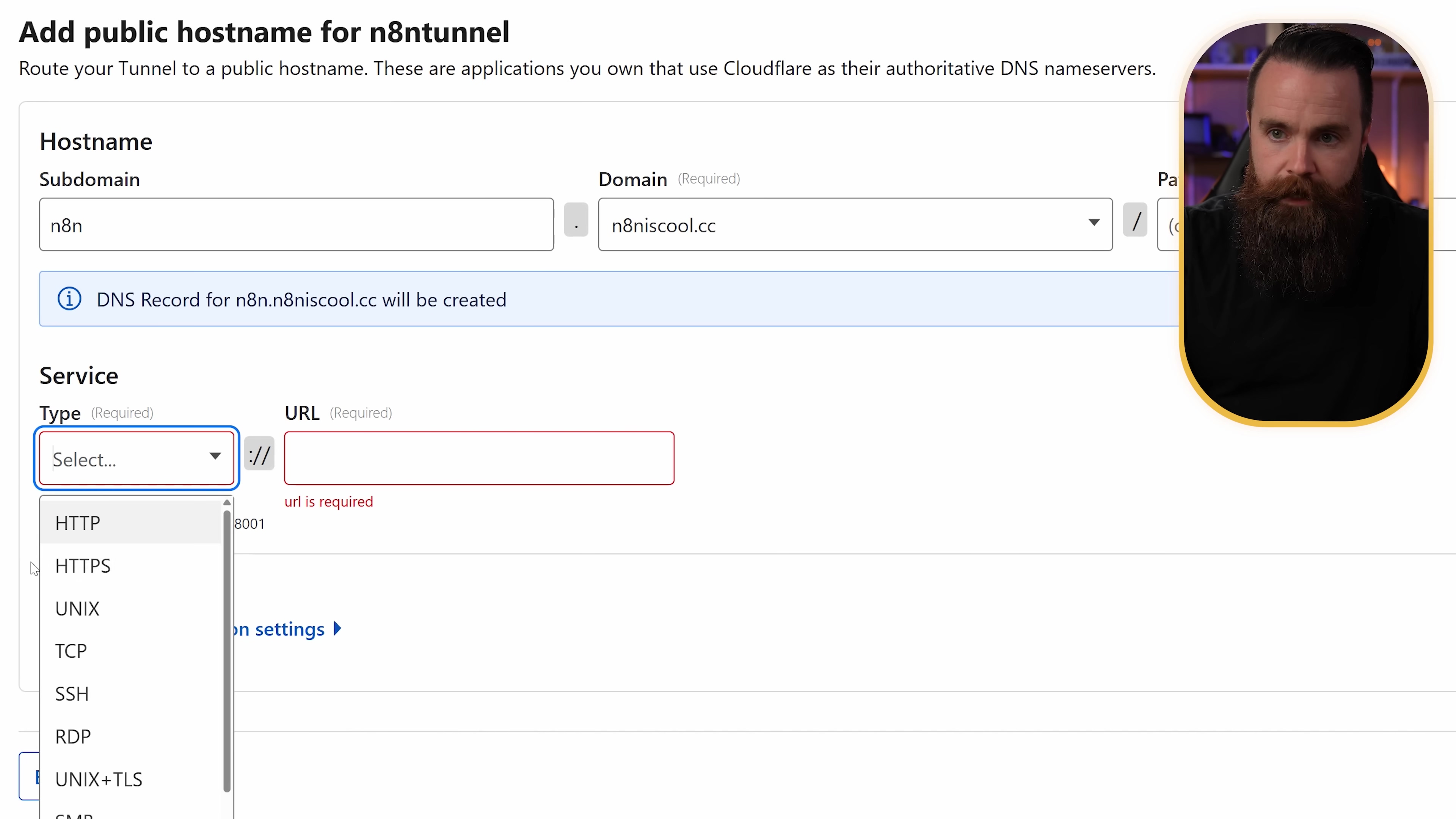 The image displays a Cloudflare dashboard interface for adding a public hostname for an n8n tunnel. The main section is titled "Add public hostname for n8ntunnel" with a description below it. There are two main input sections: "Hostname" and "Service". Under "Hostname", there are fields for "Subdomain" (pre-filled with "n8n") and "Domain" (pre-filled with "n8niscool.cc"). A dropdown menu is visible next to the domain field. Below this, a blue information icon indicates "DNS Record for n8n.n8niscool.cc will be created". The "Service" section has fields for "Type" and "URL". The "Type" field shows a dropdown menu with options like HTTP, HTTPS, UNIX, TCP, SSH, RDP, and UNIX+TLS, with HTTP selected. The "URL" field is empty and highlighted in red, indicating it is required. A message "url is required" is visible below it. A man with a beard is visible in the top right corner of the image, partially obscuring the interface.