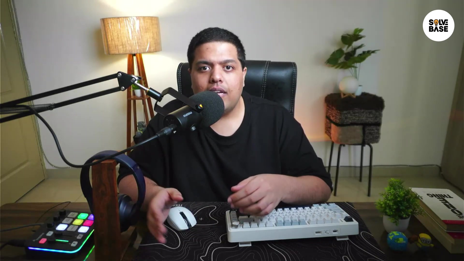 Focused individual at desk with microphone and keyboard