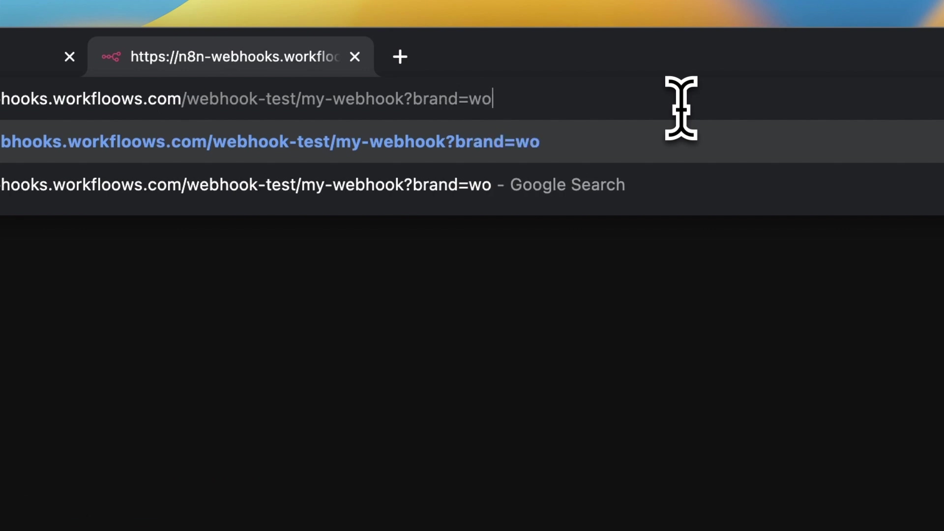 The image shows a web browser's address bar with a URL being typed or modified. The URL visible is 'https://n8n-webhooks.workfloows.com/webhook-test/my-webhook?brand=wo'. Below the address bar, a suggestion or previous search entry is displayed: 'n8n-webhooks.workfloows.com/webhook-test/my-webhook?brand=wo - Google Search'. A white cursor icon, shaped like a hand with fingers spread, is positioned at the end of the URL, indicating active text input. The browser tabs show a closed tab icon and a plus sign for a new tab. The background is dark, suggesting a dark mode browser theme.