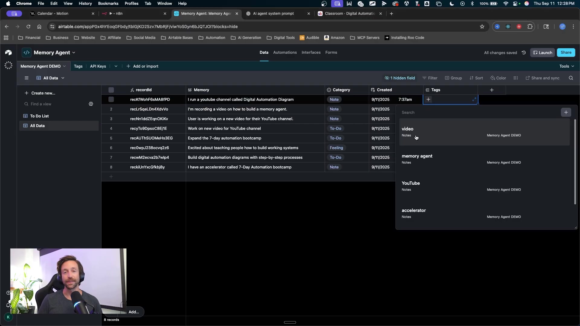 The image displays a dark-themed Airtable interface for a 'Memory Agent' project. The main section shows a table with columns like 'recordId', 'Category', 'Created', and 'Tags'. Several entries are visible, detailing tasks such as 'I run a youtube channel called Digital Automation Diagram' and 'Work on new video for YouTube channel'. A dropdown menu for 'Tags' is open on the right, showing options like 'video', 'memory agent', 'YouTube', and 'accelerator'. The top of the screen shows browser tabs and bookmarks, including 'airtable.com' and 'n8n'. At the bottom left, a person is visible in a video call window.