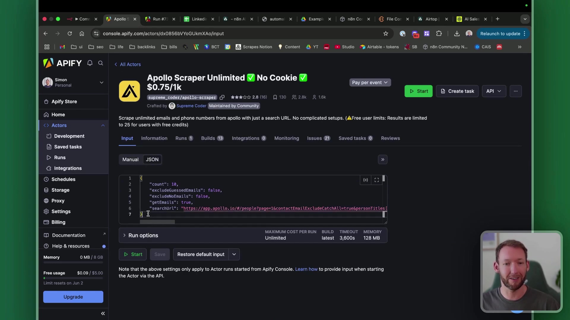 The image displays a web browser interface, likely a tool for building automations, with a focus on an 'Apollo Scraper Unlimited' actor. The main panel shows configuration options for the actor, including 'Input', 'Information', 'Runs', 'Builds', 'Integrations', 'Monitoring', 'Issues', 'Saved tasks', and 'Reviews'. A JSON input field is visible with parameters like 'count', 'excludeGuessedEmails', 'excludeNoEmails', 'getEmails', and 'searchUrl'. Below the input field, there are 'Run options' with 'MAXIMUM COST PER RUN', 'BUILD TIMEOUT', and 'MEMORY' settings. A green 'Start' button and a 'Save' button are prominent. A small video feed of a man speaking is visible in the bottom right corner. The browser tabs at the top indicate various open applications or websites, including 'Apollo', 'n8n', 'automake', and 'Airtable'.