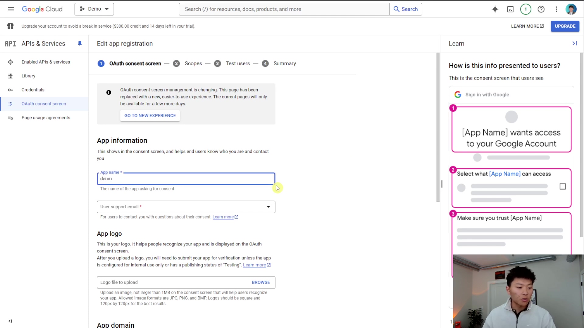 The image displays a Google Cloud console interface for editing app registration, specifically the OAuth consent screen. The main panel shows 'App information' with fields for 'App name' (filled with 'demo') and 'User support email'. There's also a section for 'App logo'. On the right, a 'Learn' panel explains 'How is this info presented to users?' with a visual example of a Google sign-in prompt showing '[App Name] wants access to your Google Account'. A person is visible in the bottom right corner, looking at the screen.